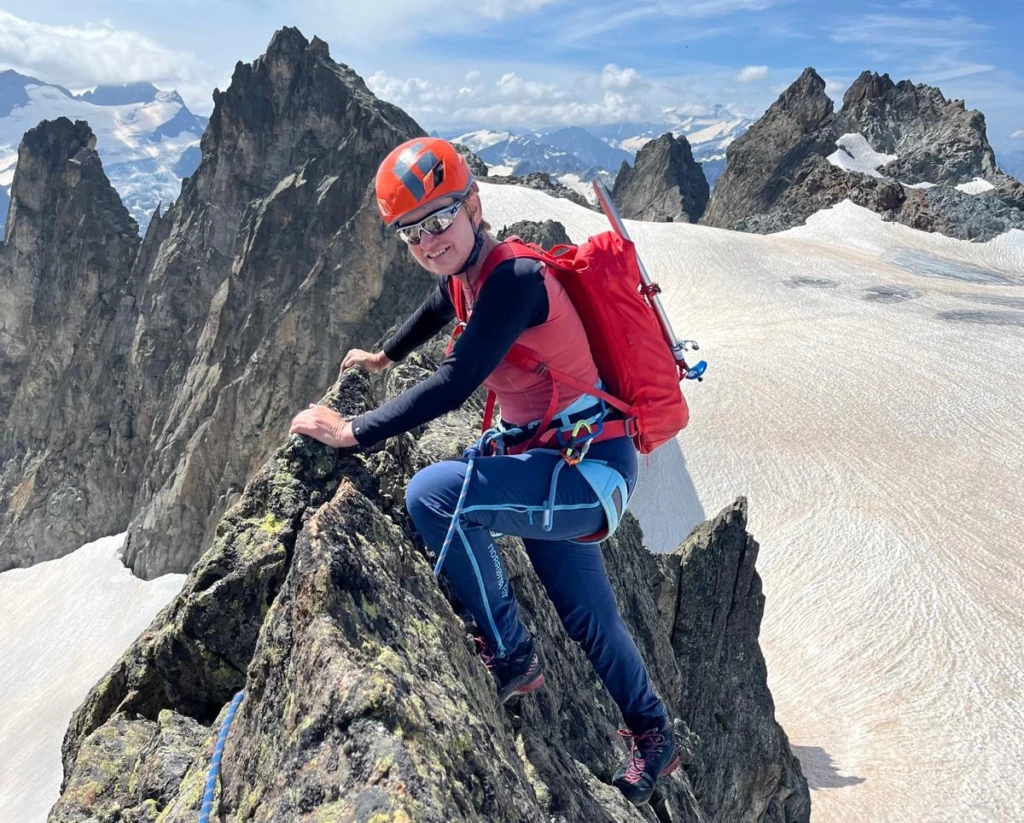 Gaby Wermelinger mit Helm und Rucksack auf einem Felsgrat